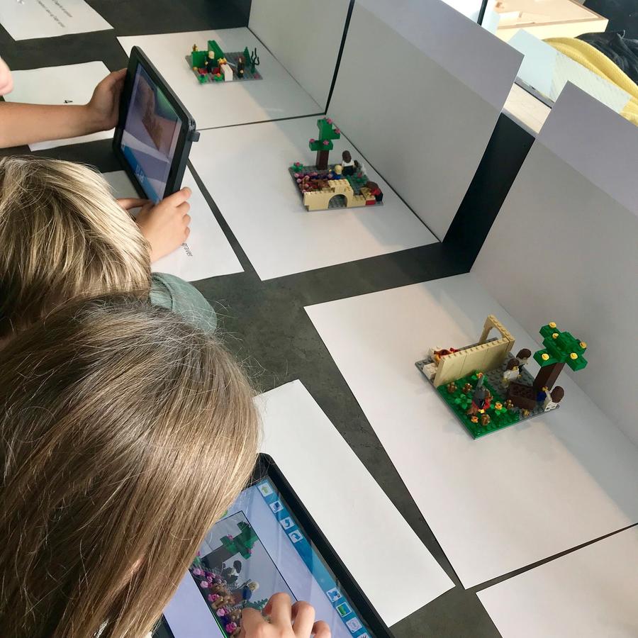 En gruppe har bygget en scene fra eventyret "Enøje, toøje, treøje" og er ved at tage billeder af det med deres Ipad