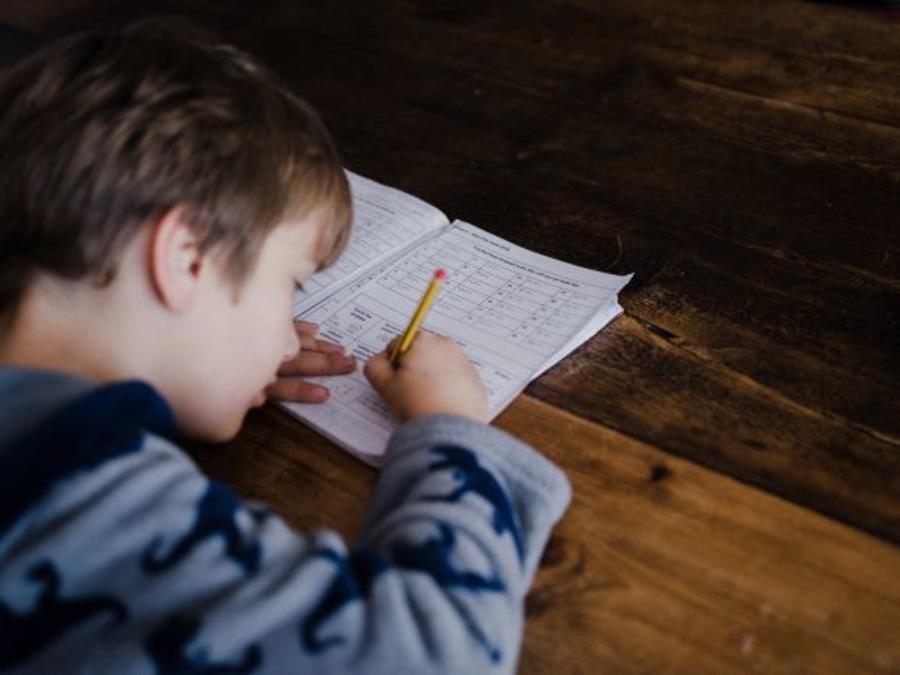 Dreng laver opgaver ved et spisebord