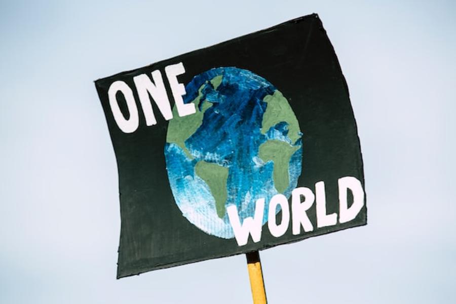 Foto: Markus Spiske / Unsplash Skilt fra en demonstration med teksten: One world