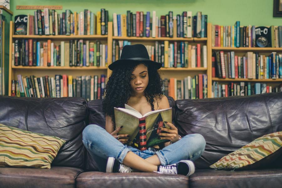 Photo by iam Se7en on Unsplash Ung kvinde sidder i en sofa med en bog